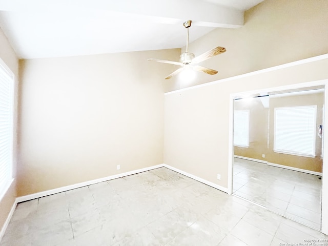 tiled spare room with ceiling fan and vaulted ceiling with beams