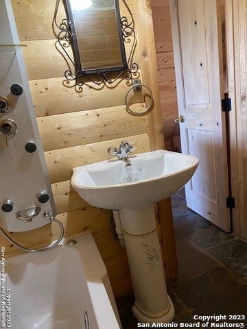 bathroom featuring wooden walls and tile flooring