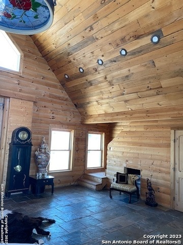 interior space with wood ceiling, dark tile flooring, and high vaulted ceiling