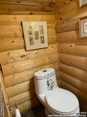 bathroom featuring rustic walls, toilet, and wooden ceiling