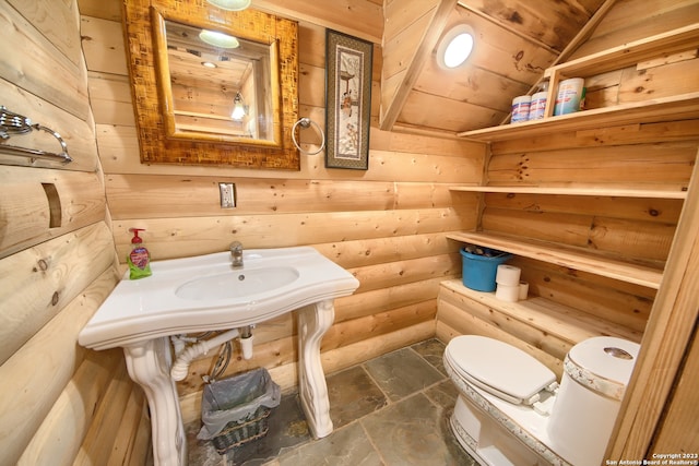 bathroom with tile floors, rustic walls, toilet, and wooden ceiling