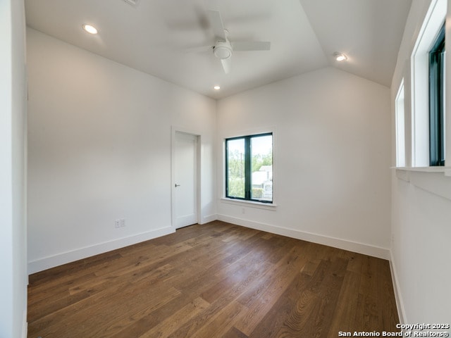 spare room featuring ceiling fan, vaulted ceiling, and dark wood-type flooring