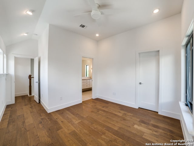 empty room with ceiling fan, lofted ceiling, and dark hardwood / wood-style floors