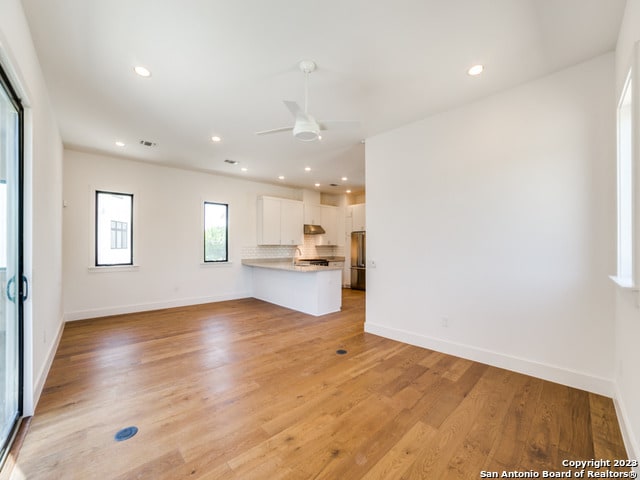 unfurnished living room with ceiling fan and light hardwood / wood-style flooring