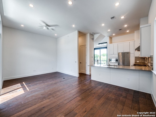 kitchen with ceiling fan, stainless steel appliances, dark wood-type flooring, and white cabinetry