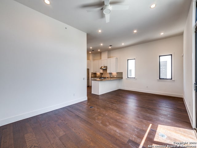 unfurnished living room with ceiling fan and dark hardwood / wood-style flooring