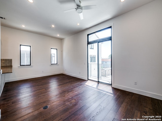 unfurnished room with dark hardwood / wood-style flooring and ceiling fan