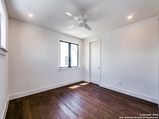 spare room with ceiling fan and dark hardwood / wood-style flooring