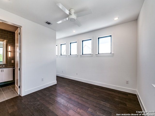 empty room with dark hardwood / wood-style floors and ceiling fan