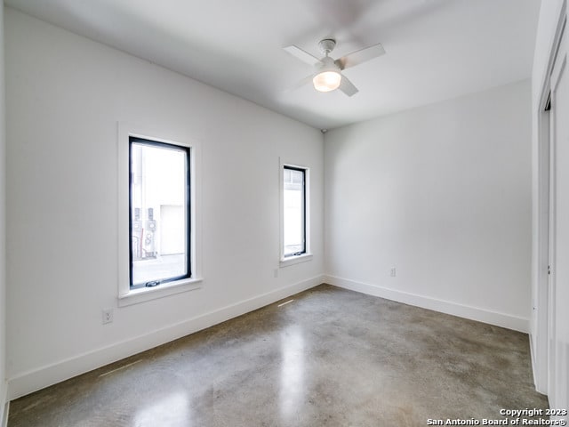 empty room featuring concrete floors and ceiling fan