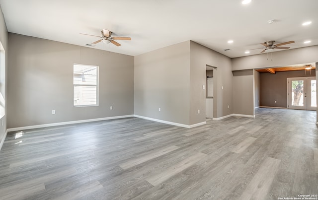 empty room featuring french doors, ceiling fan, and light wood-type flooring