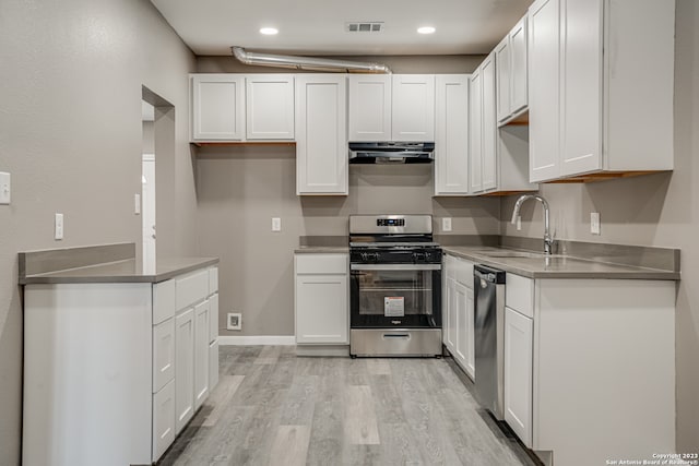 kitchen with sink, white cabinets, light hardwood / wood-style flooring, stainless steel appliances, and stainless steel counters