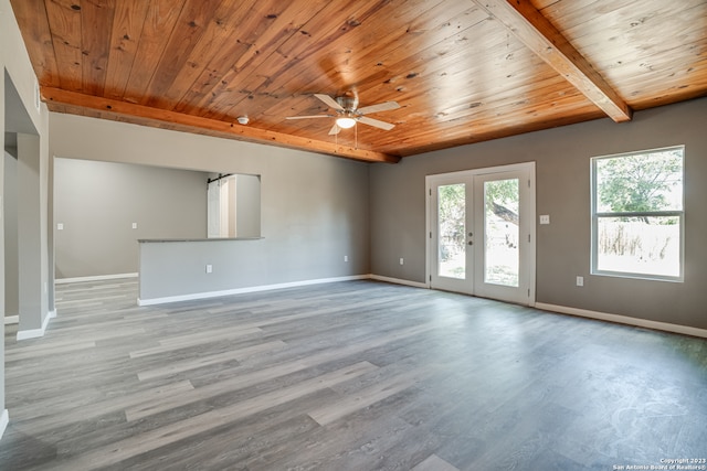 empty room featuring beamed ceiling, light hardwood / wood-style floors, french doors, ceiling fan, and wood ceiling