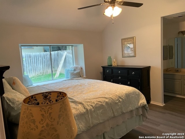 bedroom with ceiling fan, connected bathroom, dark hardwood / wood-style floors, and vaulted ceiling