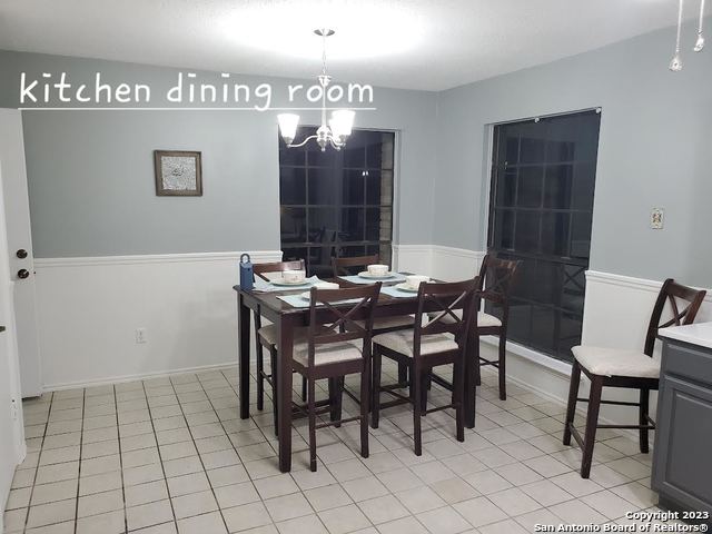 tiled dining room featuring an inviting chandelier