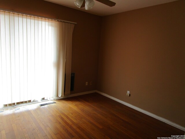 empty room featuring ceiling fan and dark wood-type flooring