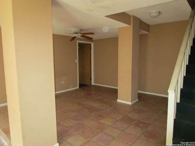 tiled spare room with ceiling fan