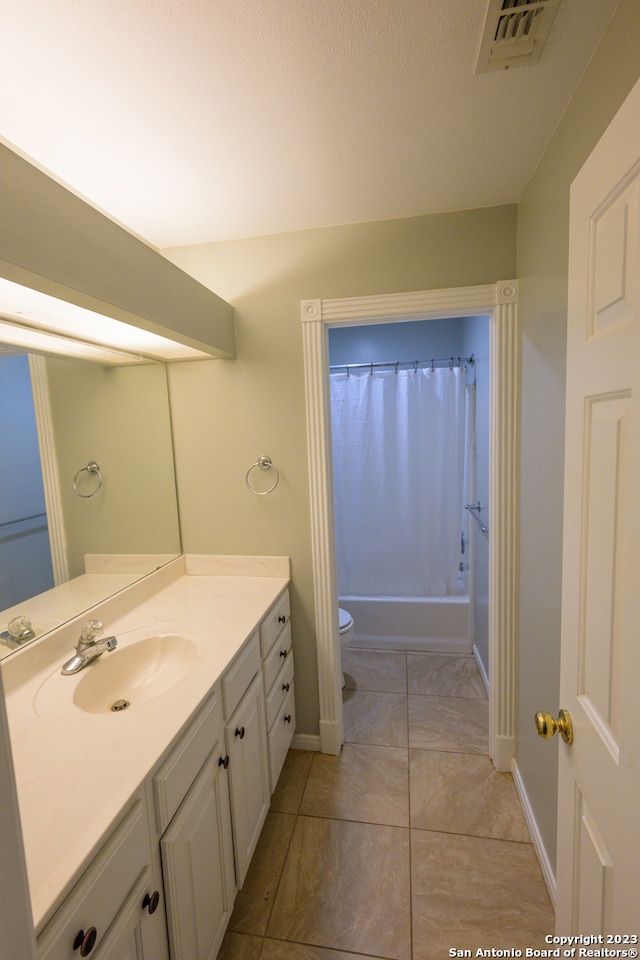 full bathroom with tile patterned flooring, toilet, vanity, and shower / tub combo with curtain