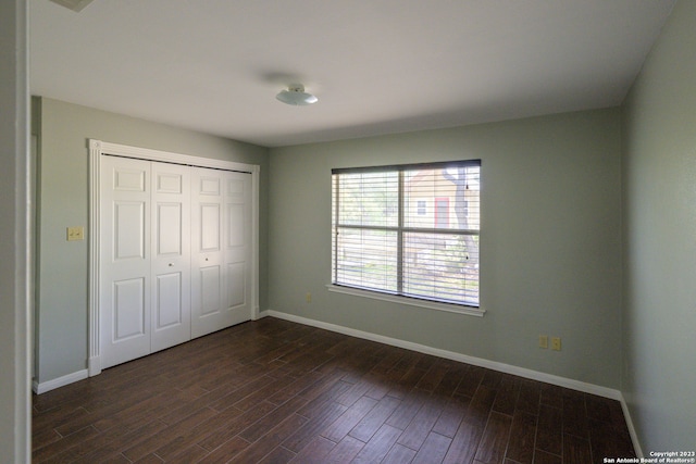 unfurnished bedroom featuring dark hardwood / wood-style flooring and a closet