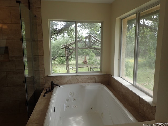 bathroom featuring a shower with door and plenty of natural light