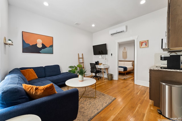 living room featuring light hardwood / wood-style flooring and a wall mounted air conditioner