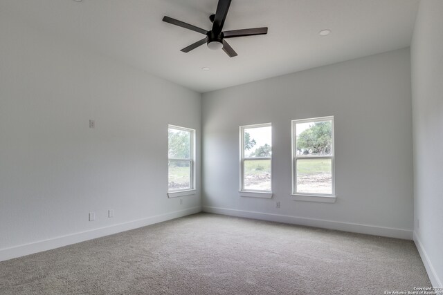 carpeted spare room featuring ceiling fan