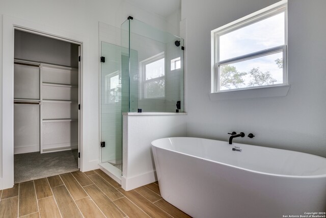 bathroom featuring independent shower and bath and wood-type flooring