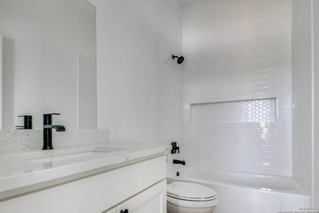 full bathroom with toilet, vanity, and tiled shower / bath