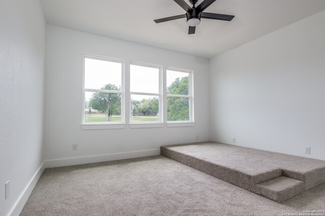 carpeted empty room featuring ceiling fan