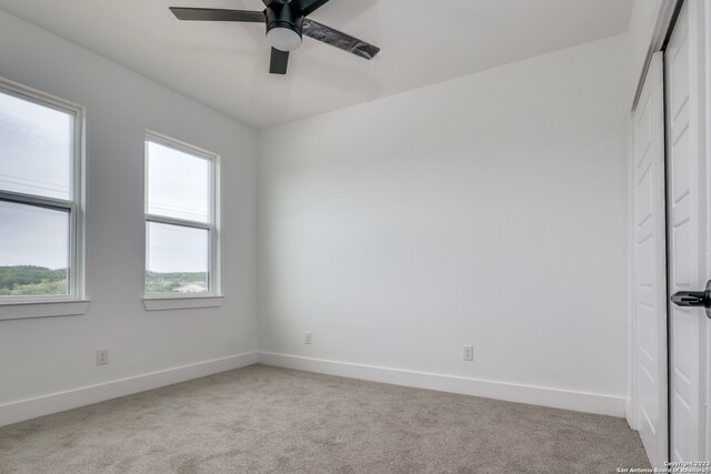 carpeted empty room featuring ceiling fan