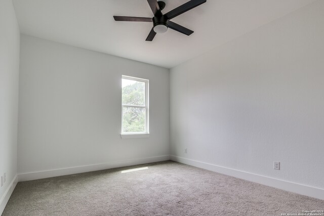 spare room with ceiling fan and light carpet