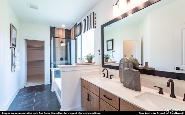 bathroom with double vanity, tile flooring, and separate shower and tub