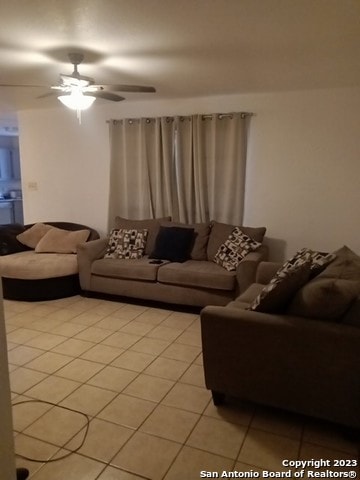 living room featuring light tile floors and ceiling fan