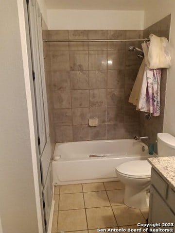 full bathroom with tile flooring, toilet, vanity, and tiled shower / bath