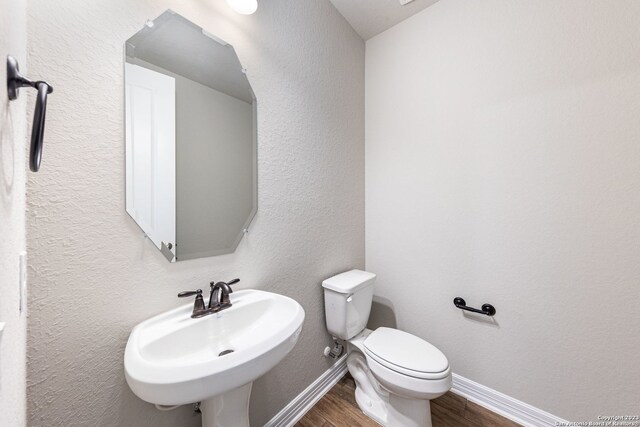 bathroom with sink, toilet, and hardwood / wood-style flooring