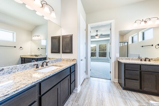 bathroom featuring ceiling fan, lofted ceiling, double sink vanity, and tile floors