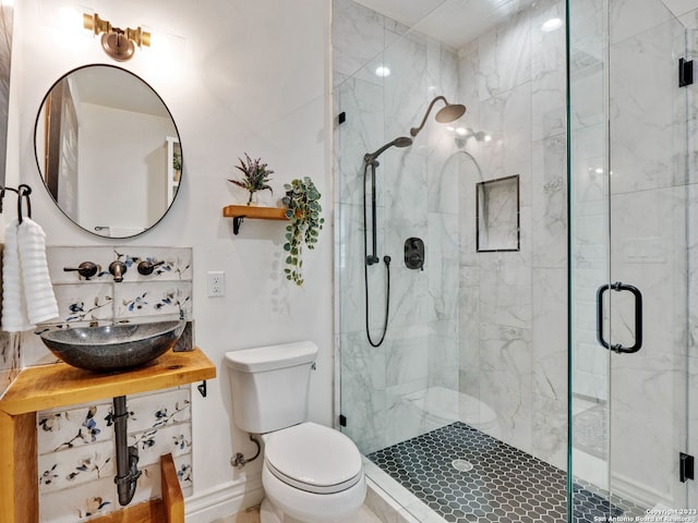 bathroom with vanity, toilet, and a shower with door