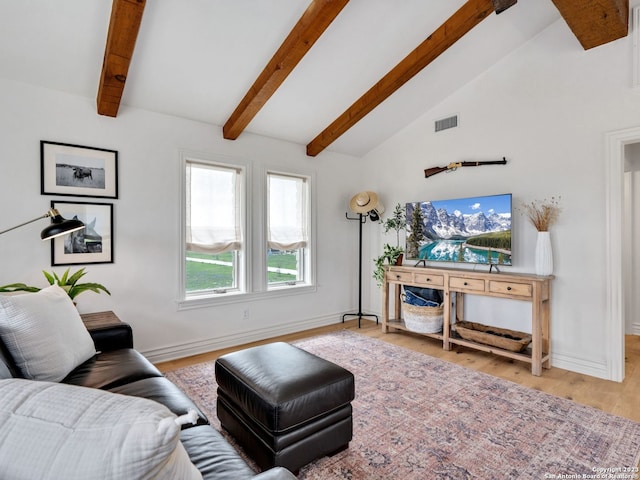 living room featuring vaulted ceiling with beams and light hardwood / wood-style flooring