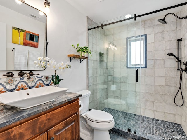 bathroom with tile floors, walk in shower, toilet, and vanity