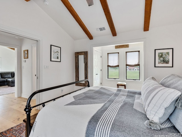 bedroom with vaulted ceiling with beams and light hardwood / wood-style flooring