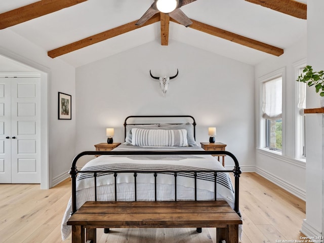 bedroom with ceiling fan, a closet, light hardwood / wood-style flooring, and lofted ceiling with beams