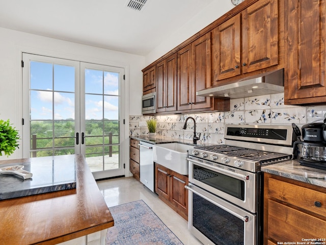 kitchen with french doors, tasteful backsplash, appliances with stainless steel finishes, and sink