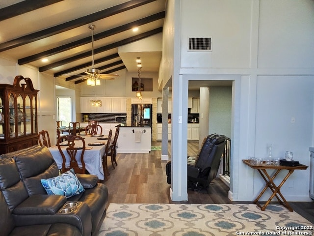 living room with high vaulted ceiling, dark hardwood / wood-style flooring, ceiling fan, and beamed ceiling