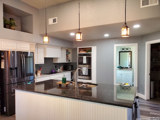 kitchen featuring pendant lighting, dark hardwood / wood-style flooring, white cabinets, and appliances with stainless steel finishes