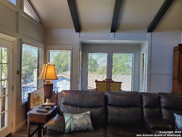 living room with lofted ceiling with beams