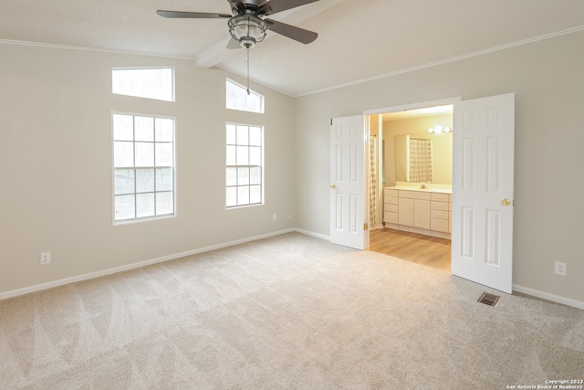 unfurnished bedroom with light colored carpet, ceiling fan, ensuite bathroom, and lofted ceiling with beams