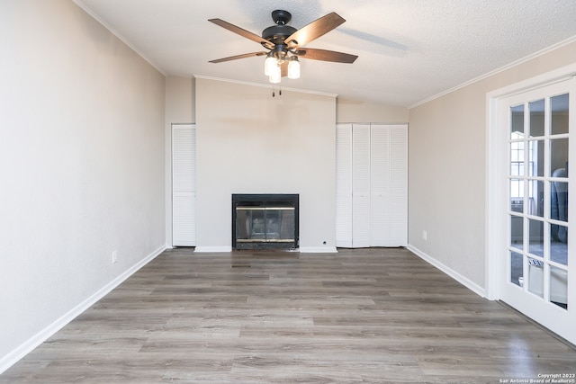 unfurnished living room featuring ceiling fan, a textured ceiling, ornamental molding, hardwood / wood-style floors, and lofted ceiling