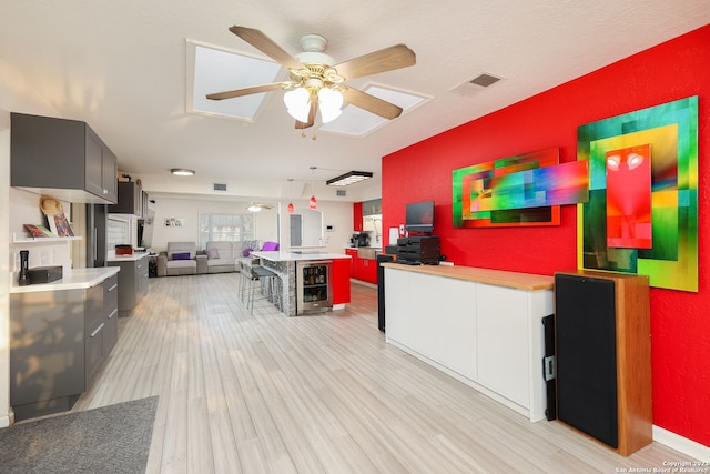 kitchen with light hardwood / wood-style flooring, pendant lighting, and ceiling fan