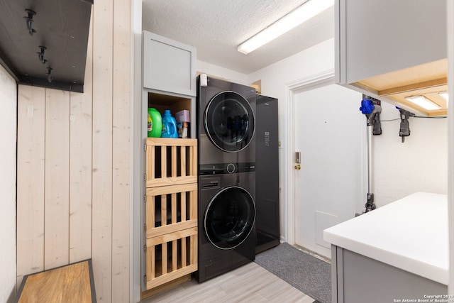 clothes washing area with stacked washer and dryer