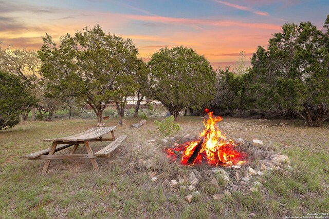 yard at dusk featuring an outdoor fire pit